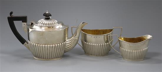 An Edwardian demi fluted silver batchelors three piece oval tea set, William Devenport, Birmingham, 1902, gross 14 oz.